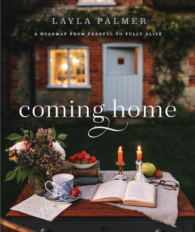 Cover image of Coming Home by Layla Palmer features a table holding an open book in front of a house